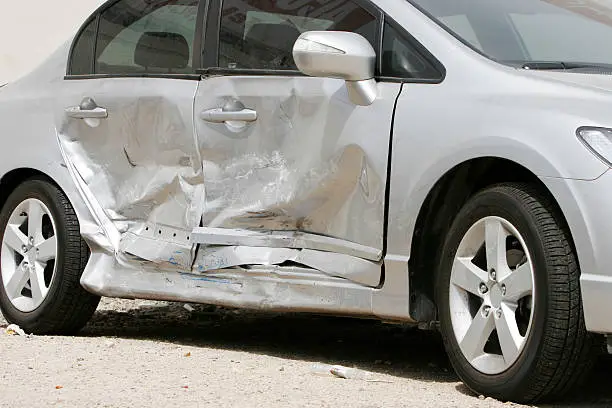 Photo of Silver car with a large dent in the side, ruining two doors