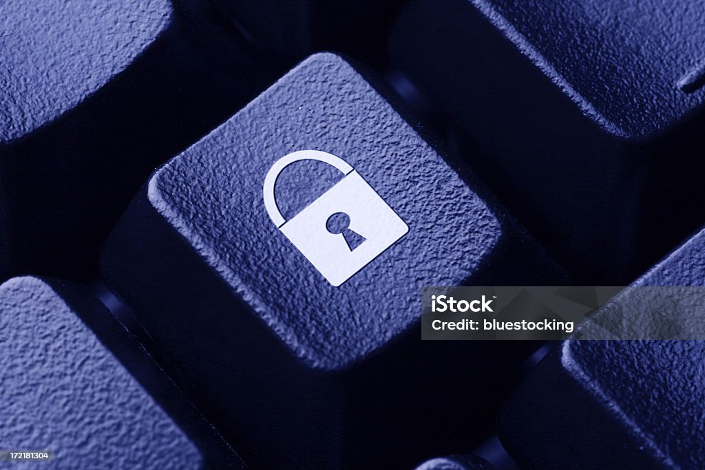 Computer Security Close-up of a lock icon on a computer keyboard button.  Blue-toned. Encryption Stock Photo