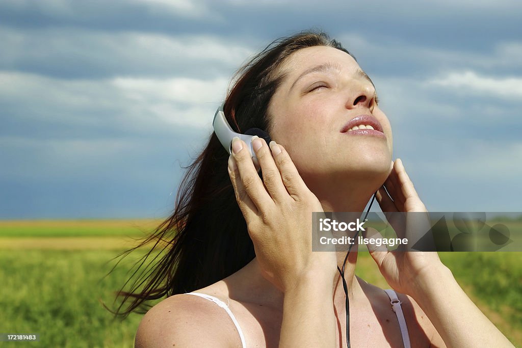 Femme écoutant de la musique dans une prairie - Photo de Adulte libre de droits