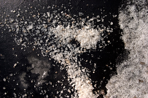 Salt on asphalt with snow right frame.