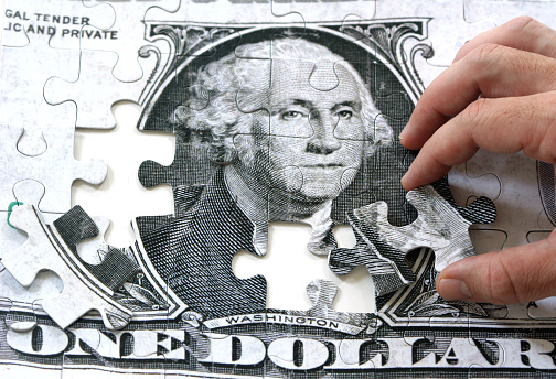 a man putting together a dollar puzzle, on white 