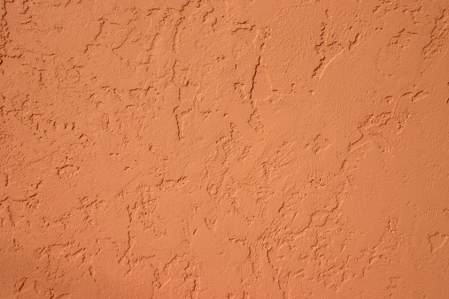 Terra cotta colored stucco surface. Textured surface. Adobe wall.