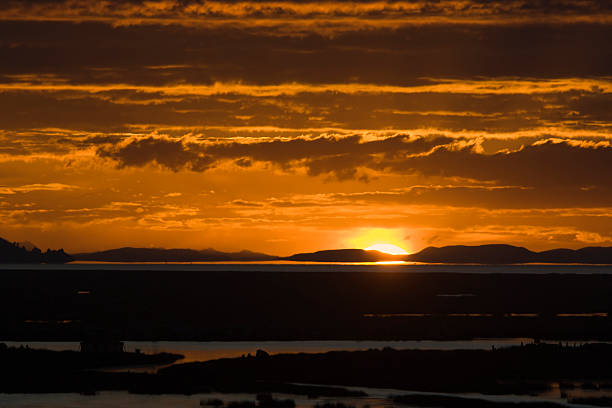 Subject: Sunrise over Lake Titicaca, with the floating islands of the indigenous villages in the foreground.