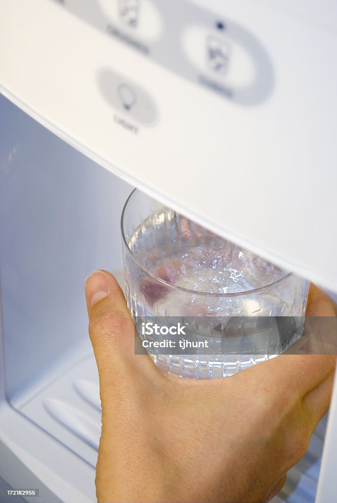 Refreshing water from fridge "Getting a glass of cold, refreshing water from the refrigerator." Water Cooler Stock Photo