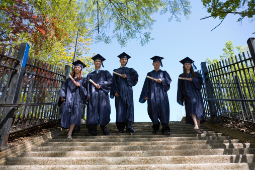 Five graduates walking down the stairs