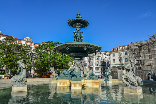 Lisbon, Portugal - July 2, 2019: fountain at the popular Rossio Square (also known as Pedro IV Square or PraÃ§a de D. Pedro IV)