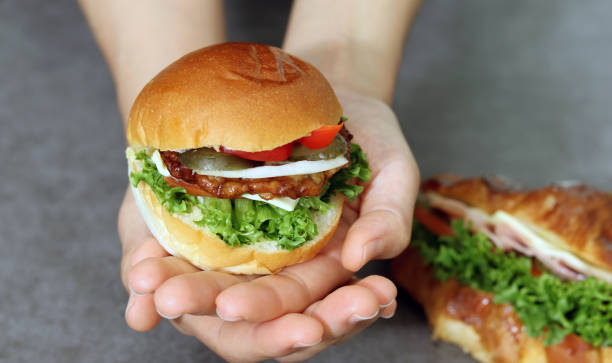 istock Close up image of a hand holding a hamburger. 1721842017