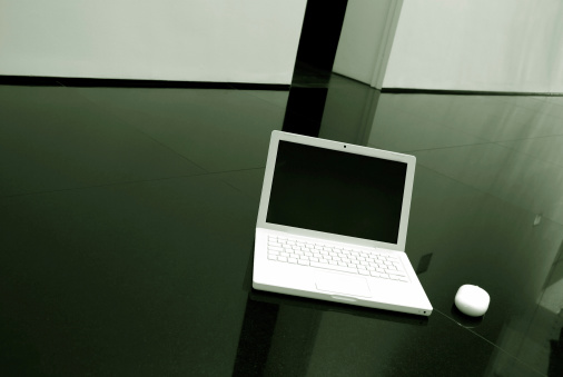 white laptop on black granite in a modern architects house.