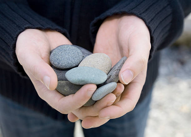 Experience the tactile connection with nature – rocks in the hands, a symbol of strength, stability, and groundedness.