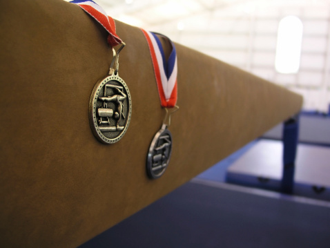 gynanstics medals on a balance  beam with shallow depth of field   
