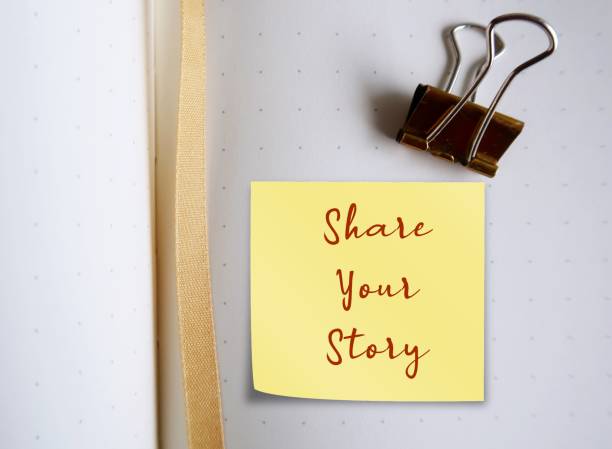 Blank notebook with text on stick note SHARE YOUR STORY, concept of start writing, blogging , story telling to share to the readers in the world by publishing it or in social media