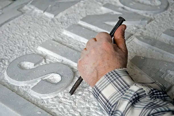 marble worker is making a tombstone. 