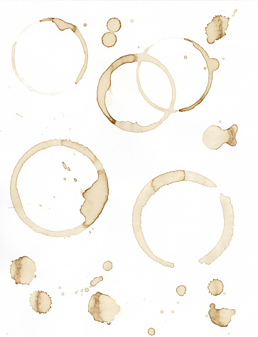 Coffee stains in a variety of shapes and splatters. Different shaped rings, some complete circles and some broken. 