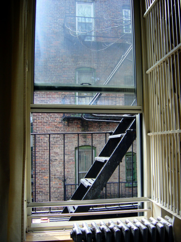 an open window leading to a fire escape of an east village new york city apartment building