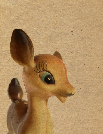 Vintage kitsch deer figurine on cardboard background