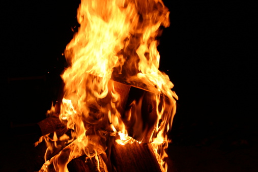 Burning cardboard boxes erupt into flames.