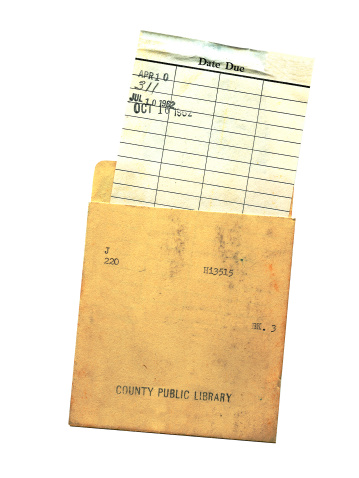 Photo of the back of a library/school date due card and holder from the early 60's.  Isolated on white and shows some grunge.