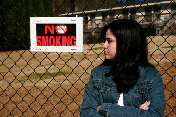 Teen Girl and No Smoking Sign stock photo