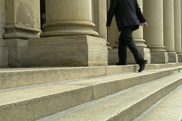 homme d'affaires marche dans les escaliers - marble building photos et images de collection