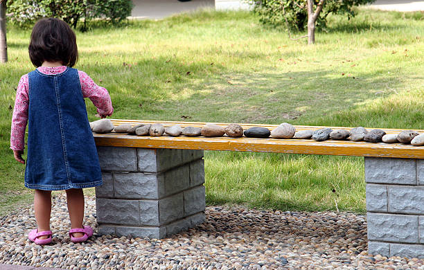 Counting Rocks A young girl counting her rocks putting everything into perfect order. obsessive stock pictures, royalty-free photos & images