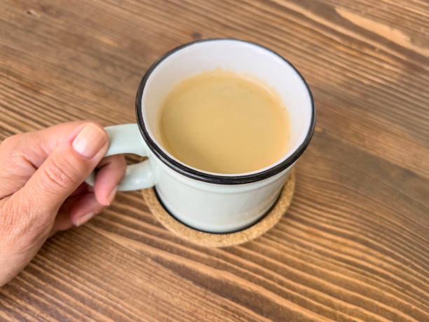 istock hand holds cup of coffee latte on wooden table 1721898646