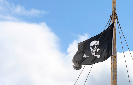 Jolly Roger in the mast of a pirate ship.