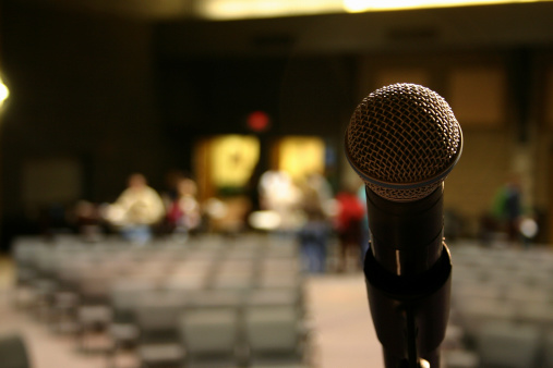 A lone microphone on stage as the auditorium begins to fill.