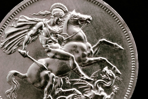 Macro detail of an old british silver sovereign coin (Five Shilling Coin).  Showing St George slaying the dragon.