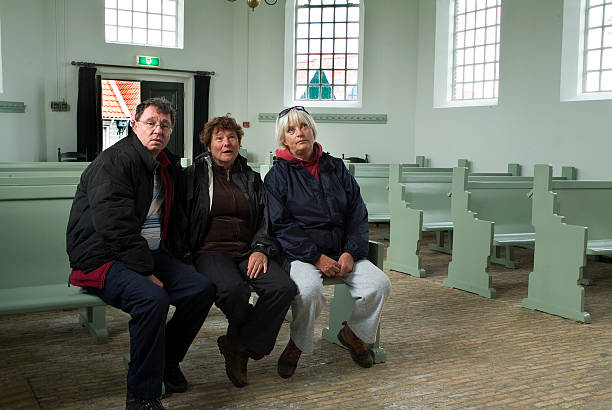 Three seniors in a church lookin up stock photo