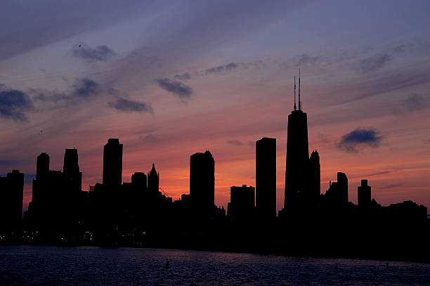 Chicago Skyline Silhouette The Chicago Skyline is silhouetted aginst the setting sun. blackout stock pictures, royalty-free photos & images