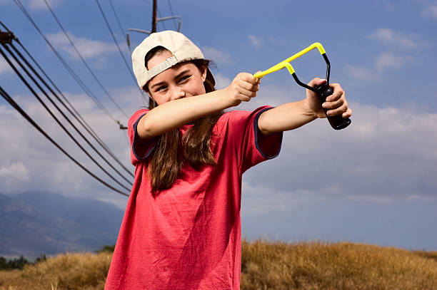 Little boy playing with slingshot at outdoors
