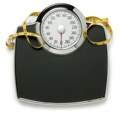 A bathroom scale and tape measure on white with soft shadow