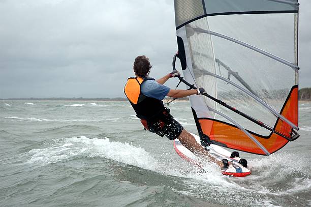 istock Windsurfer cruising by rear view 172192413