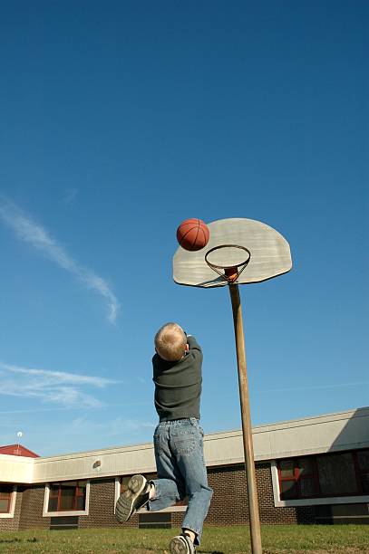 istock Young Boy Shooting Baskets in the Schoolyard 172193106