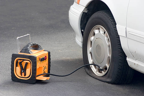portable air compressor a flat tire is tended to by a portble air compressor inflating photos stock pictures, royalty-free photos & images