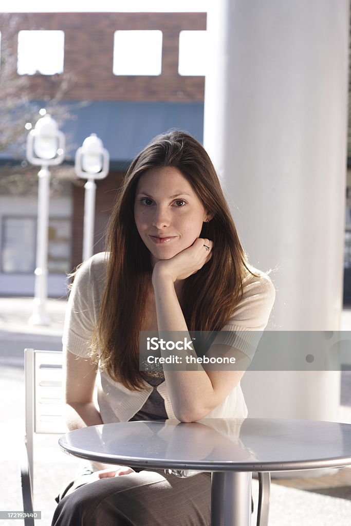 Hermosa mujer sentada en una Mesa del café - Foto de stock de 18-19 años libre de derechos
