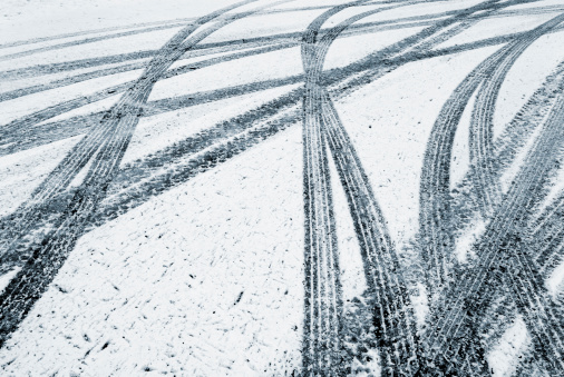 Cars leave their mark in the fresh fallen snow in a parking lot on a Monday morning.