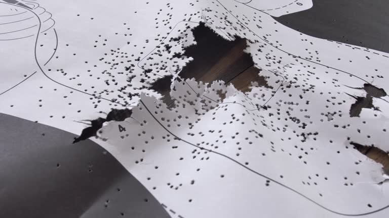 Bullet-Riddled Human Silhouette Paper Shooting Target Close-Up