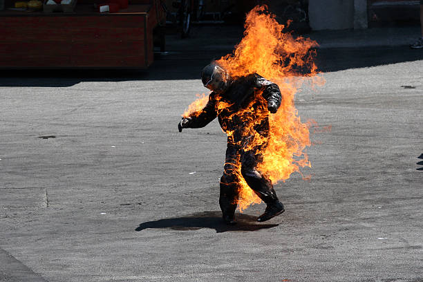 Man in a protective suit wrapped in flames stock photo