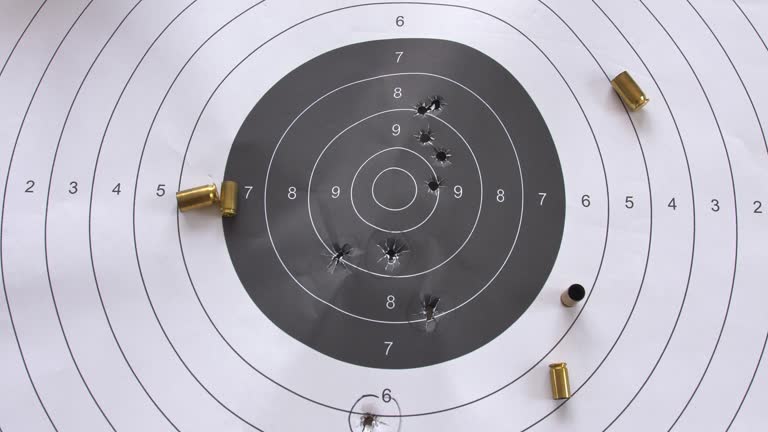 Bullet-Riddled Paper Shooting Target with Spent Shell Casings Close-Up