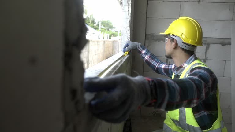 Architect  measuring and marking frame at site.