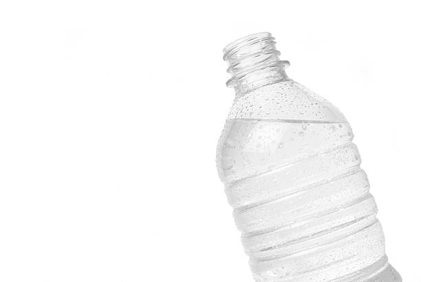 Studio image of an open bottle of water on a white background. The bottle looks so cold and refreshing with the water droplet condensation along outside of the bottle. The bottle is at a slight angle causing the water not to be level with the bottle creating more visual interest.