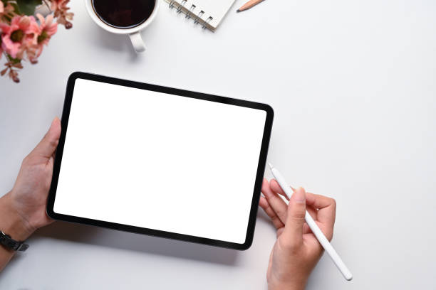 istock Above view of woman using digital tablet on white office desk. Blank screen for your advertising text message 1721949695
