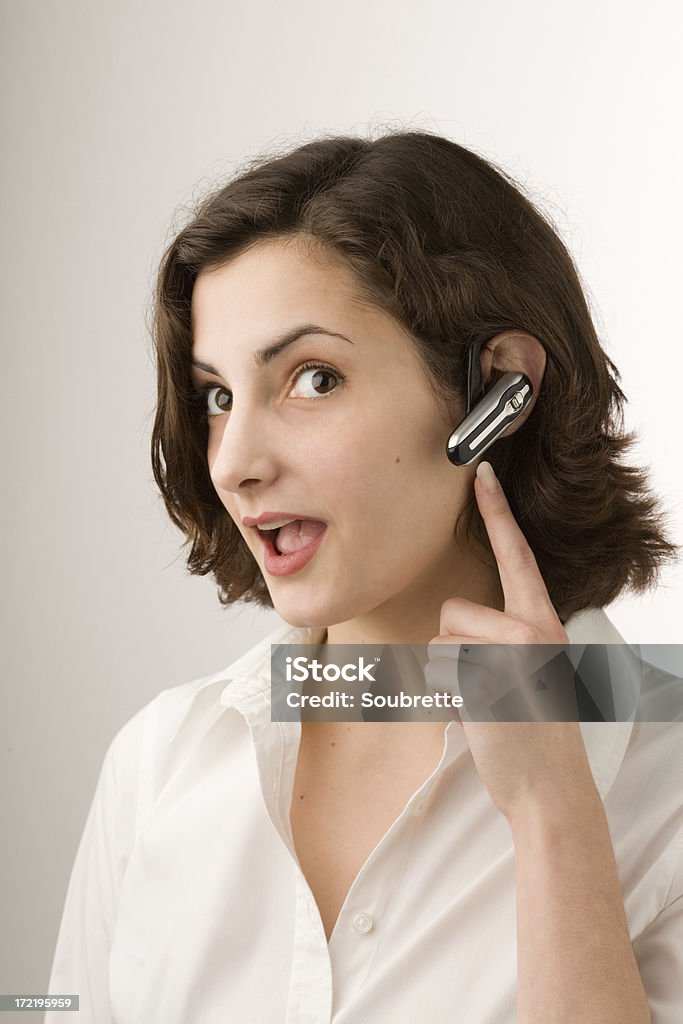 Young Business Woman "A lovely young business woman in a fresh bright setting pointing to her bluetooth headset. For more pictures in this series, see my lightbox:" 20-24 Years Stock Photo