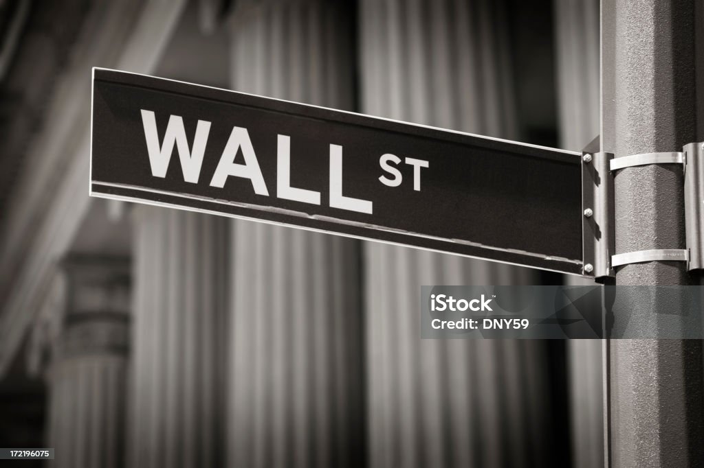 Wall Street Sign Wall St. street sign with financial institution behind it Business Stock Photo