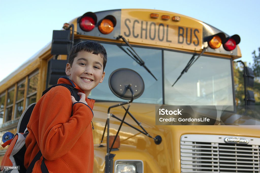 Smiling boy near the school bus A smiling boy stands near the school bus going to (or from) school.  Additional images of this model School Bus Stock Photo