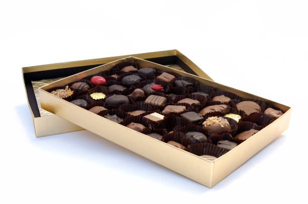 Box of chocolates on top of lid on white background stock photo
