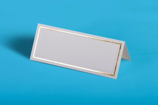 A blank formal place card on a blue background