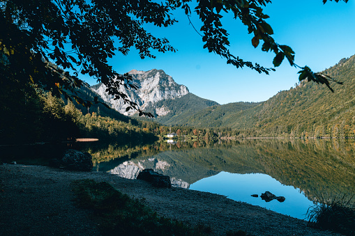 Tranquil mountain lake reflecting picturesque autumn scenery in Austria.