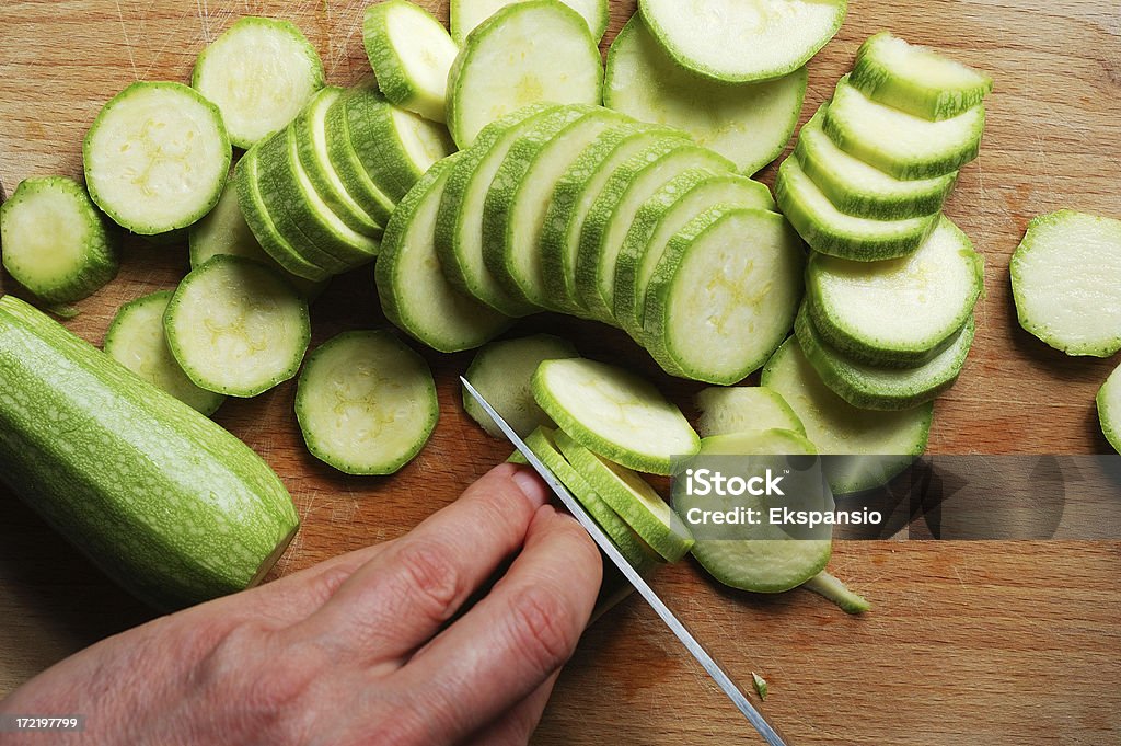 Chopping Zucchini on a cutting board Blade Stock Photo